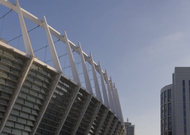 Binaların arka planına karşı bir spor stadyumunun yapısal unsurları