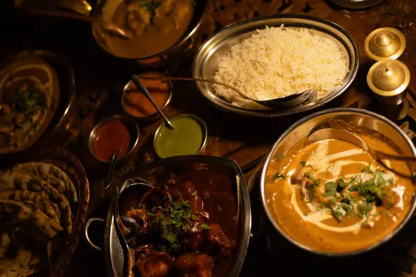 Masa Hint yemekleriyle kaplı, soslar tabakta.