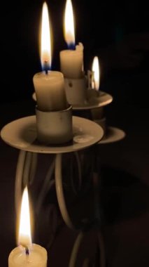 Bir şamdanda üç mum, ateş titriyor.