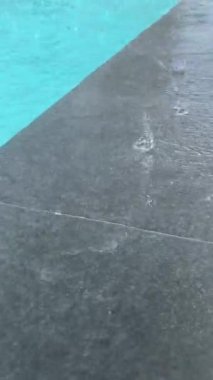 Yağmur damlaları açık havuzun suyuna damlıyor.