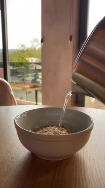 Çaydanlıktan kaynayan suyla yulaf ezmesi, kahvaltı.