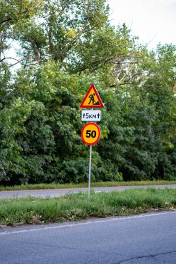 Yol tabelaları ileride inşaat çalışması olduğunu gösteriyor, sürücüleri sapma ve güvenlik önlemlerine karşı uyarıyor. Trafik yönetimi, kentsel gelişim veya altyapı projelerini resmetmek için ideal. Herhangi bir taşımacılık veya inşaatla ilgili içerik için hayati bir görüntü.