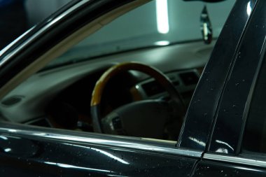 Arabanın içini açık bir pencereden görmek modern tasarımı, lüks koltukları ve yüksek teknolojili gösterge panelini gösteriyor. Otomotiv reklamları, seyahat ve yaşam tarzı kavramları için ideal.