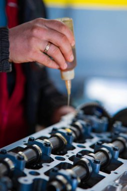 Yetenekli bir tamirci bir araba motorunu titizlikle tamir eder, uzmanlık ve detaylara dikkat gösterir. Bu resim otomotiv işçiliğinin özünü yakalar ve motor bakımı için gerekli olan ithafı vurgular. Resmetmek için mükemmel