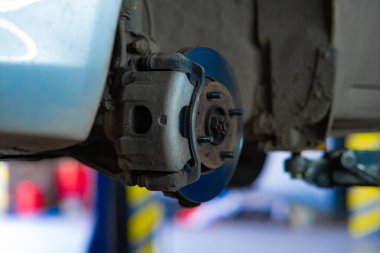 Karmaşık tasarım ve mühendisliği vurgulayan fren diskiyle bir araba merkezinin yakın çekimi. Otomotiv tamiri, bakım ve teknoloji temaları için ideal.