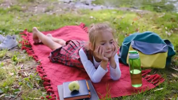 Bir Liseli Kız Nehrin Yakınındaki Bahçede Çimlerin Üzerinde Yatıyor — Stok video