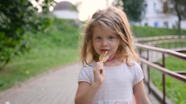 Una Niña Está Caminando Por Calle Comiendo Caramelos Primer Plano — Vídeo de stock