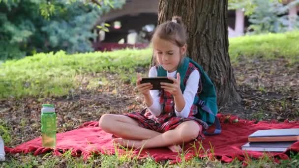 Kaygısız Küçük Bir Kız Çevrimiçi Bir Oyun Oynuyor Akıllı Telefon — Stok video