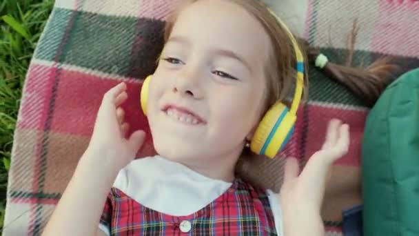 Uma Menina Com Fones Ouvido Ouvindo Música Deitada Rua Vista — Vídeo de Stock