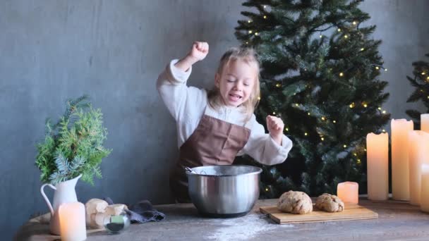 Een Klein Meisje Een Schort Danst Aan Keukentafel Tijdens Voorbereiding — Stockvideo