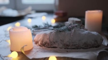 Tahta bir masanın üzerinde kış tatili süslemeleri ile ev yapımı Noel çalı. Geleneksel Noel şekerleme tatlısı Stollen 'dır..