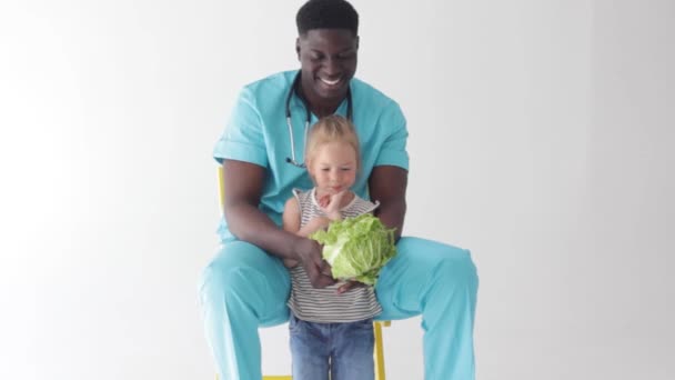 African American Doctor Shows Little Girl Cabbage Head Concept Proper — Stock Video