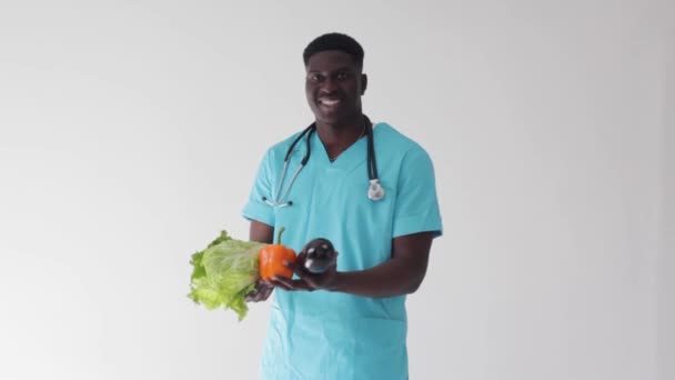 一位白人背景的非洲裔美国医生展示了蔬菜的适当营养概念 — 图库视频影像