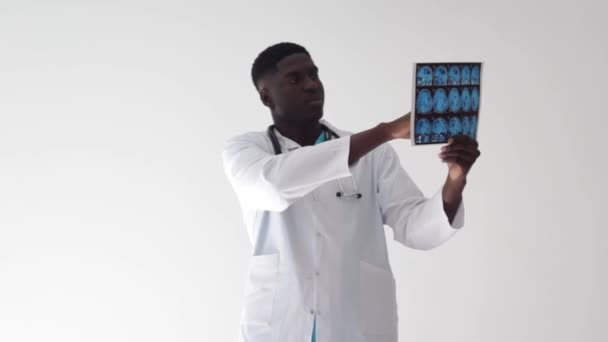 白人背景的非洲医生研究脑断层扫描图像 — 图库视频影像