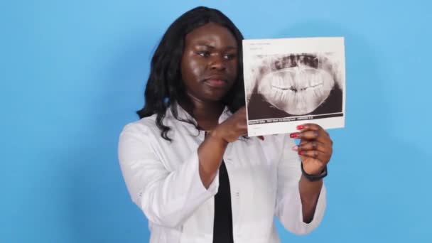 Afroamerykańska Dentystka Bada Zdjęcie Szczęki Odizolowanym Niebieskim Tle — Wideo stockowe