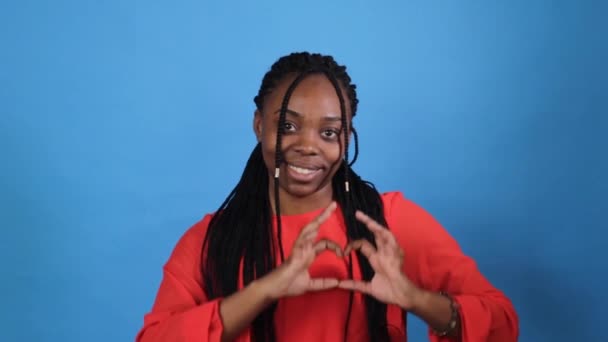 Een Afro Amerikaans Meisje Een Rode Jurk Vertoont Een Teken — Stockvideo