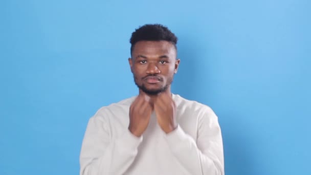 Afrikansk Man Vit Tröja Ler Tittar Kameran Isolerad Blå Bakgrund — Stockvideo
