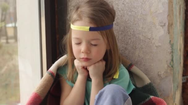 在乌克兰 一个小女孩坐在窗前祈祷和平 — 图库视频影像