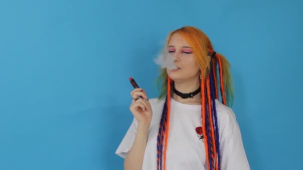 Modern Hipster Girl Colored Hair Smokes Vape Blue Background Fashionable — Stock Video