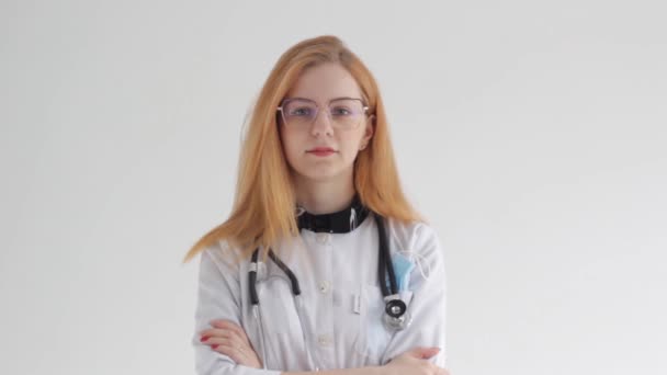 Młody Rudowłosy Lekarz Dziewczyna Powoli Uśmiecha Się Białym Tle — Wideo stockowe