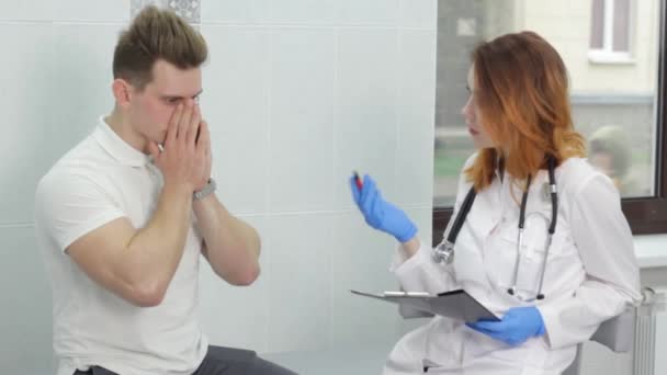 Girl Doctor Conducts Consultation Man Suffering Severe Headache — Vídeos de Stock