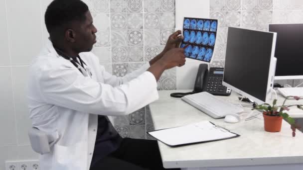 一位美国医生仔细检查了磁共振成像记录 落后国家的现代医学 — 图库视频影像