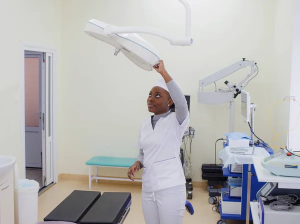 African American Girl Doctor Adjusts Lighting Lamp Surgery Room — Stock Photo, Image