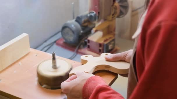 一个人拿着一个木制小方块 用磨床加工它 木制儿童玩具的生产 — 图库视频影像