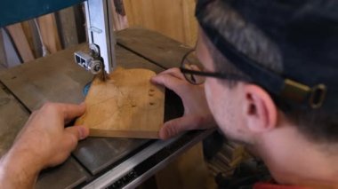 the master drills holes in a wooden billet on a drilling machine