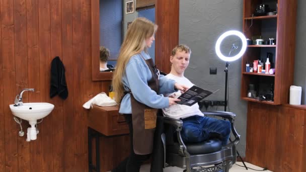 Młody Mężczyzna Niepełnosprawnością Omawia Fryzurę Swoim Mistrzem Salonie Fryzjerskim — Wideo stockowe