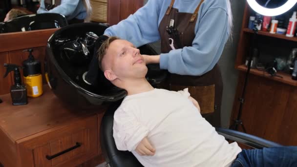 Ein Friseurmädchen Wäscht Einem Mann Mit Behinderungen Einem Schönheitssalon Sanft — Stockvideo