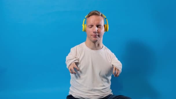 Człowiek Niepełnosprawnością Wrodzona Patologia Rąk Odizolowanym Niebieskim Tle Słucha Muzyki — Wideo stockowe