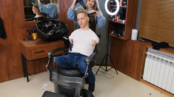 ハンドエリアの障害者の青年が理容室で散髪をしています — ストック写真
