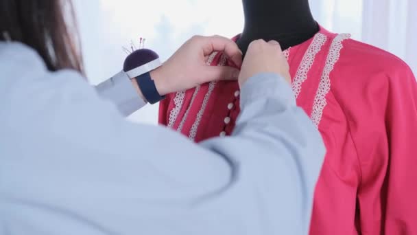 Ένα Κορίτσι Σχεδιάστρια Μόδας Κουμπώνει Ένα Κόκκινο Φόρεμα Ντυμένο Μια — Αρχείο Βίντεο