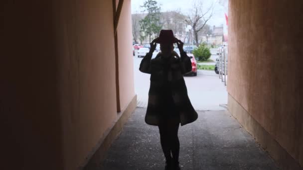 少女は通路を暗いアーチの中を歩き帽子を頭にかぶり — ストック動画