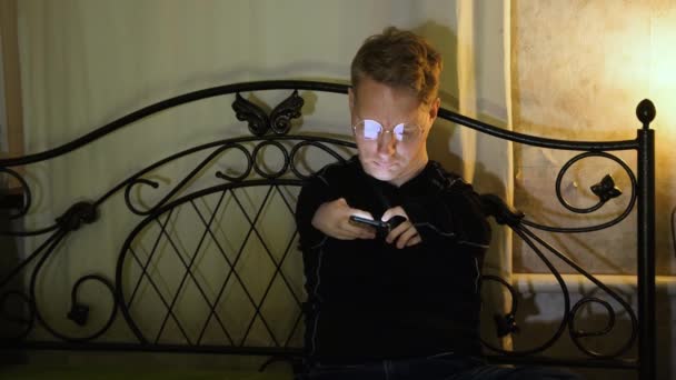 一名残疾男子正坐在床上用手机工作 — 图库视频影像
