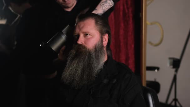 一个留着胡子的男人被理发店里的理发师用吹风机梳理的特写镜头 — 图库视频影像