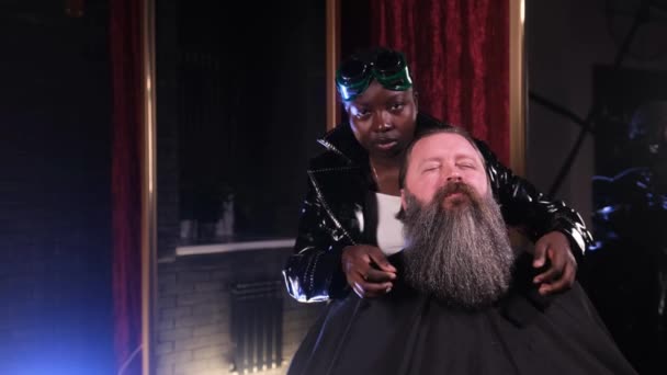 Afroamerykańska Fryzjerka Prostuje Brodę Dłońmi Mężczyzny Siedzącego Fotelu — Wideo stockowe
