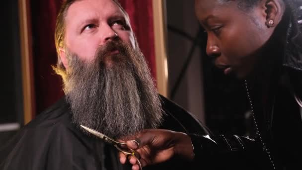 Afroamerykańska Fryzjerka Czarnym Płaszczu Przecięła Facetowi Brodę Nożyczkami — Wideo stockowe