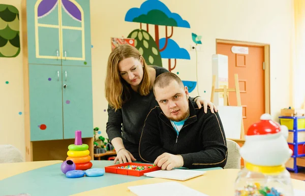 stock image a psychologist is engaged with an adult autistic man in the office.