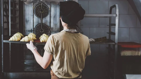 Una Mujer Trabajadora Utiliza Horno Para Hornear Croissants Concepto Panadería — Foto de Stock