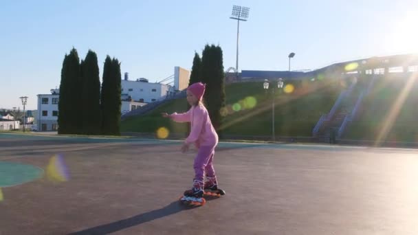 Little Girl Pink Sweater Learns Rollerblade Stadium Sunset — Stock Video