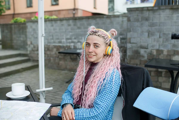 셔츠를 매력적 관광객 커피를 마시고 헤드폰으로 음악을 듣는다 분홍색 머리를 — 스톡 사진