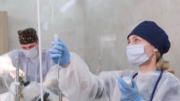 在手术的背景下 在静脉内放水 一位戴无菌手套的女医生准备给病人做手术 — 图库视频影像