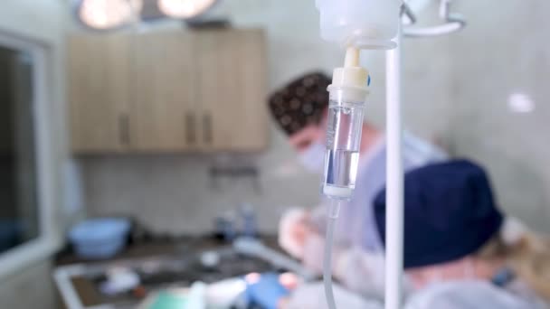 Goutte Goutte Médical Pend Sur Trépied Devant Une Équipe Chirurgiens — Video