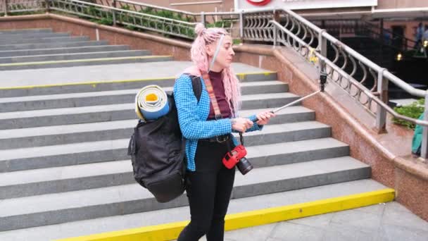 大きなバックパックを持つ観光客の女の子は アクションカメラで自分自身の写真を撮り 旅行ブログを保つ — ストック動画