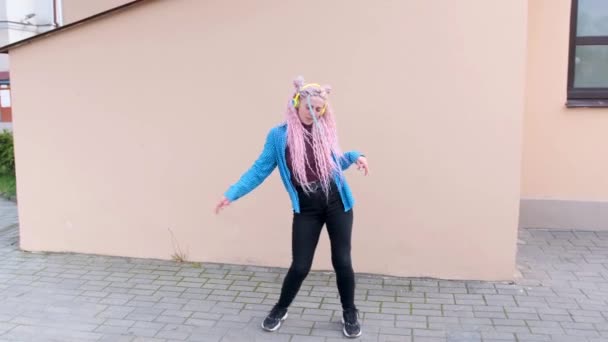 Ένα Κορίτσι Ροζ Μαλλιά Χορεύει Χαρούμενα Έναν Ροζ Τοίχο — Αρχείο Βίντεο