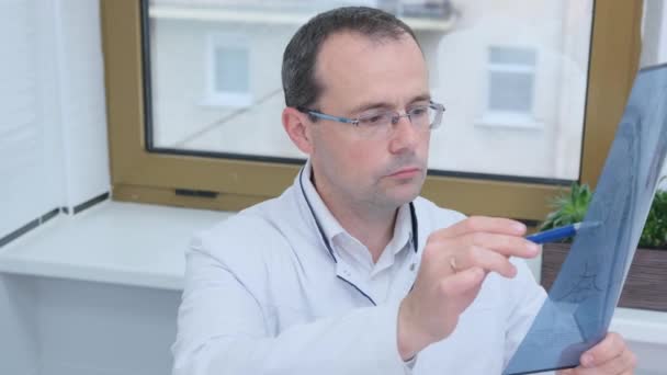 男性の医師が脳のCtスキャン結果を調べる — ストック動画