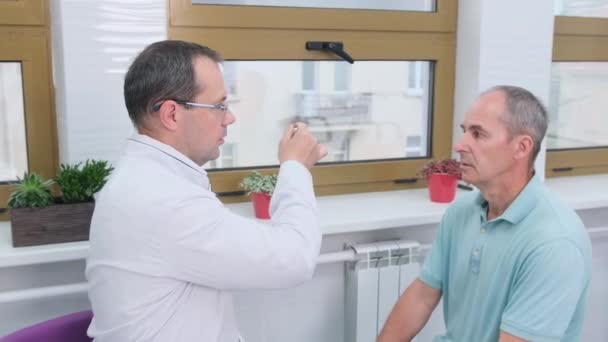 Neurolog Flyttar Hammare Framför Äldre Patients Ögon Läkarundersökning Kliniken — Stockvideo