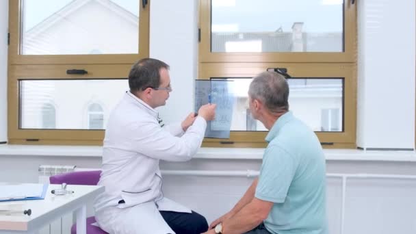 Manlig Läkare Förklarar Diagnosen För Manlig Patient Genom Att Rita — Stockvideo